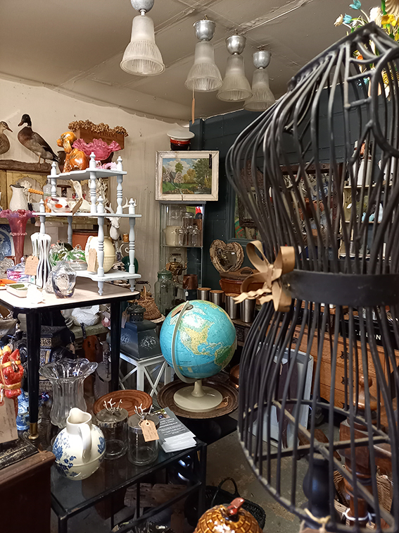 a corner of the shop with various shelves and an antiq
ue tailors dummy