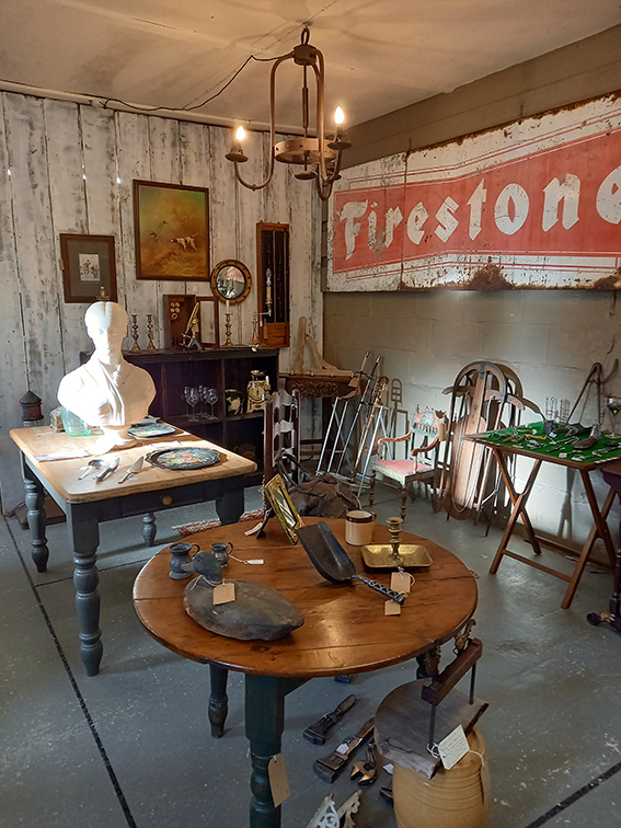 a corner of the shop with tables and a large sign saying firestone