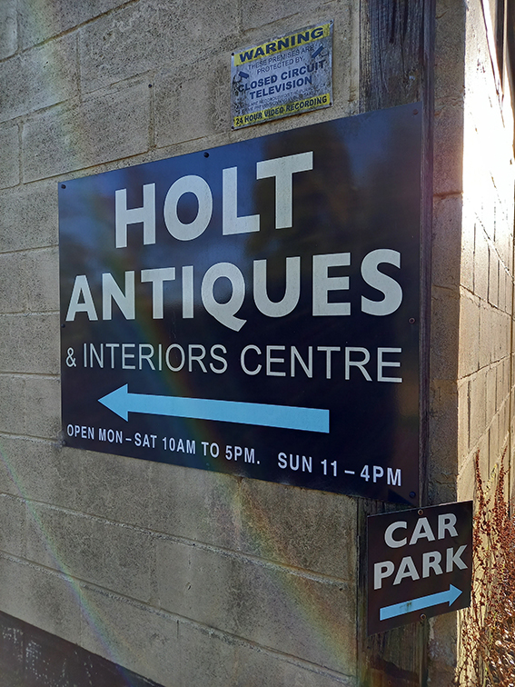 An exterior sign on a brick wall that says Holt Antiques